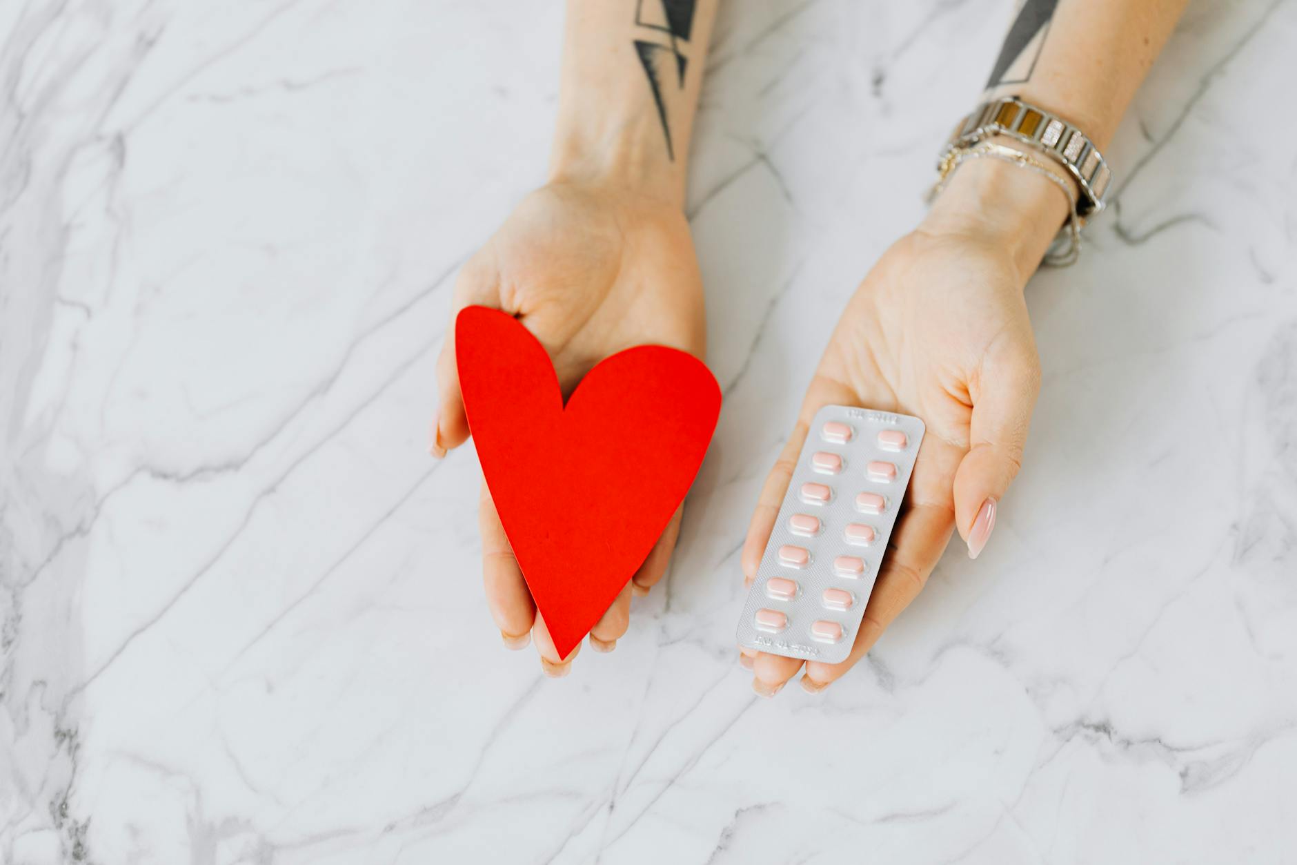 hands with pills and heart shaped paper